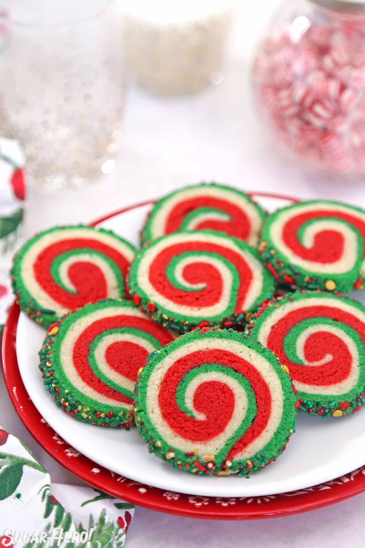 Christmas Pinwheel Cookies on a white plate with peppermint candies in the background.