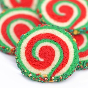 Close-up of red, white, and green Christmas Pinwheel Cookies on white plate.