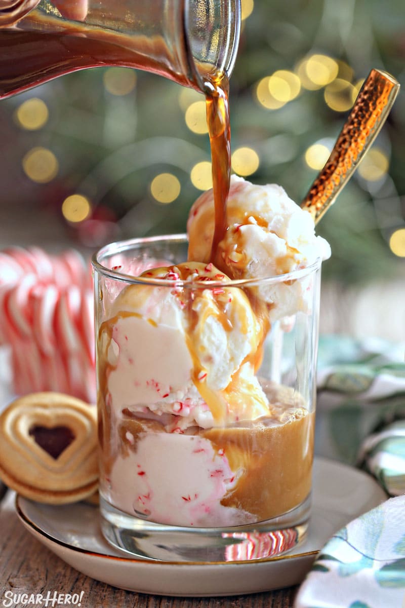 Hand pouring coffee over a clear glass filled with peppermint ice cream.