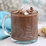 Peppermint Hot Chocolate in a glass mug with cocoa whipped cream on top.