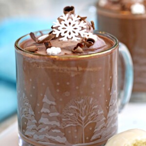 Peppermint Hot Chocolate in a glass mug with cocoa whipped cream on top.