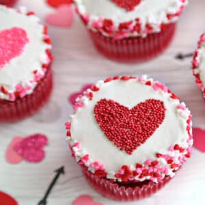 Close up of a Sprinkle Heart Cupcake with a red heart.