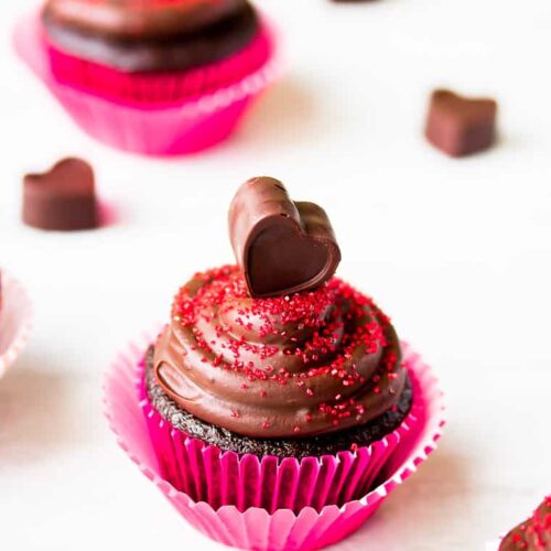 A single Chocolate Raspberry Cupcake in a hot pink wrapper and topped with a chocolate heart.