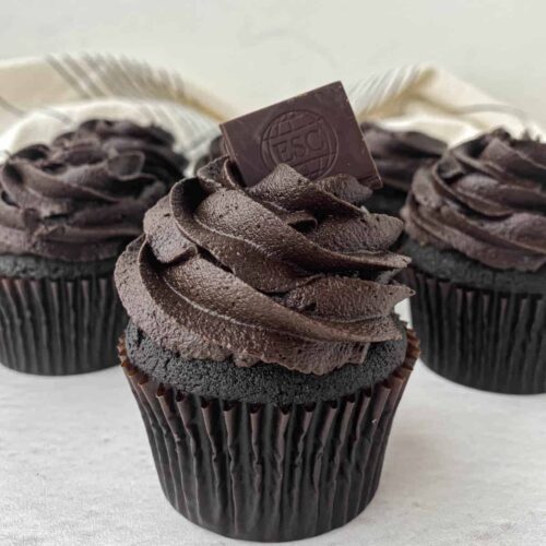 Close up of a Death by Chocolate Cupcake with a wedge of chocolate on top.