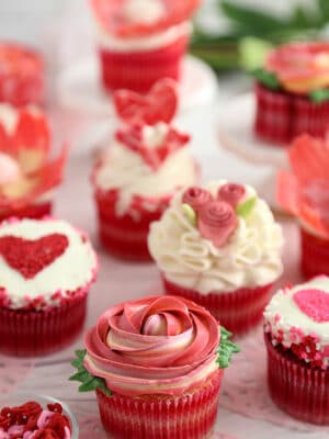 Group of Valentine's Day cupcakes decorated with various flower and heart designs.