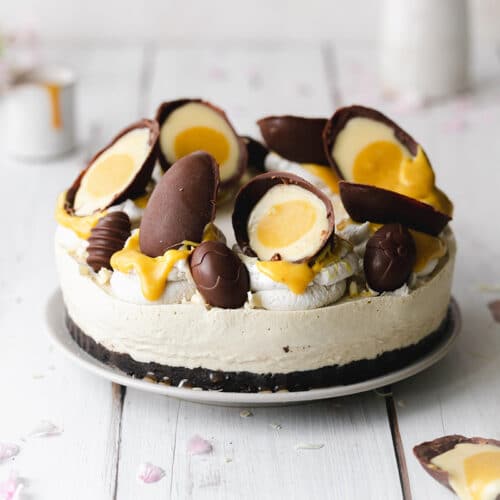 Cheesecake with creme eggs on top on a white plate.