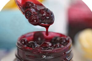 Pinterest collage of blueberry sauce in a glass jar with text that reads "BLUEBERRY SAUCE".