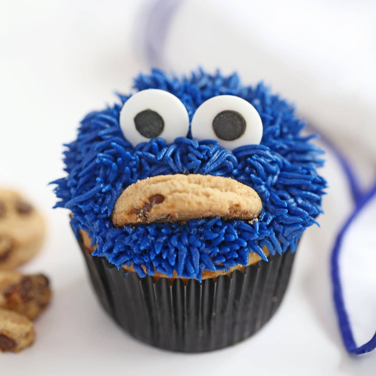 Close-up of Cookie Monster Cupcake with cookies on the side.