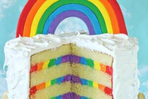 Photo of bright Rainbow Cake with text overlay for Pinterest.