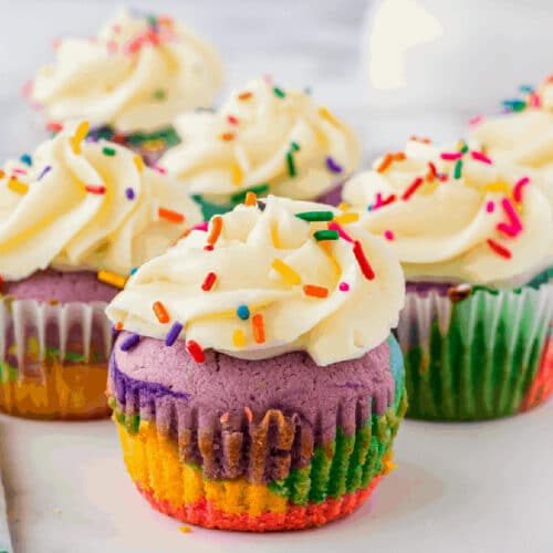 Rainbow cupcakes with buttercream frosting and rainbow jimmies on top.