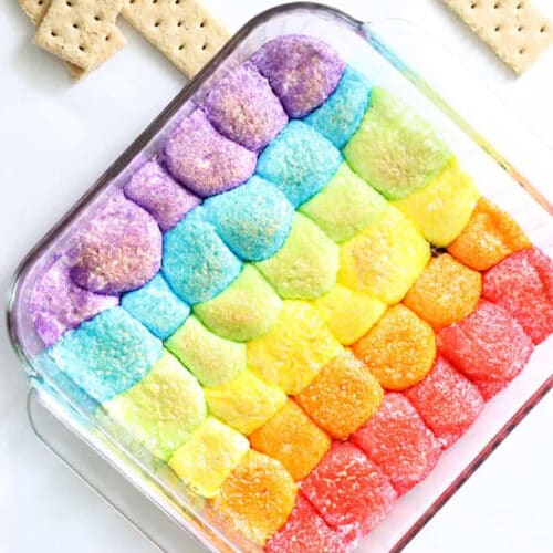 Square glass pan with puffed marshmallows in rainbow colors with graham crackers around.
