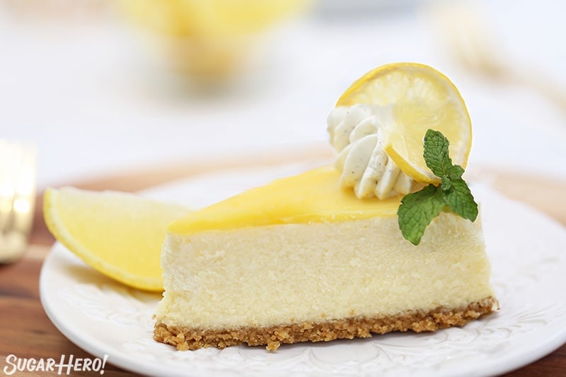 Slice of cheesecake with lemon curd and fresh mint on top.