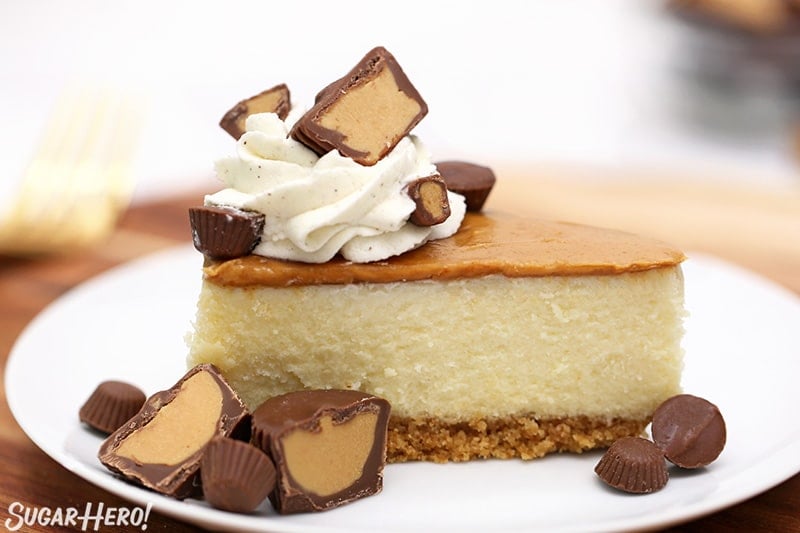 Slice of cheesecake with peanut butter, whipped cream, and peanut butter cups on top.