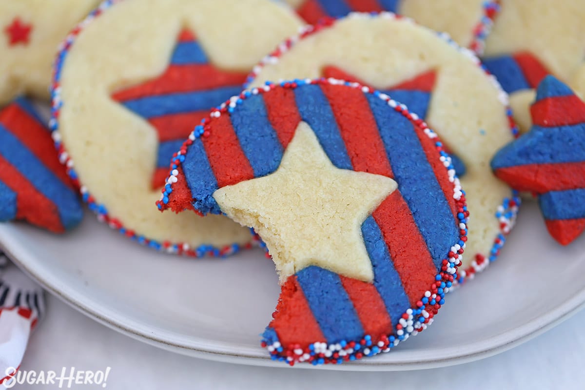 Close-up of Stars and Stripes Sugar Cookies with a bite taken out of one of them.