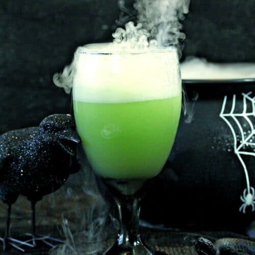 Witch's Brew Halloween Punch shown in a black cauldron with dry ice leaking out of the cauldron.