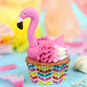 Close up of a Flamingo Cupcake on a blue surface.