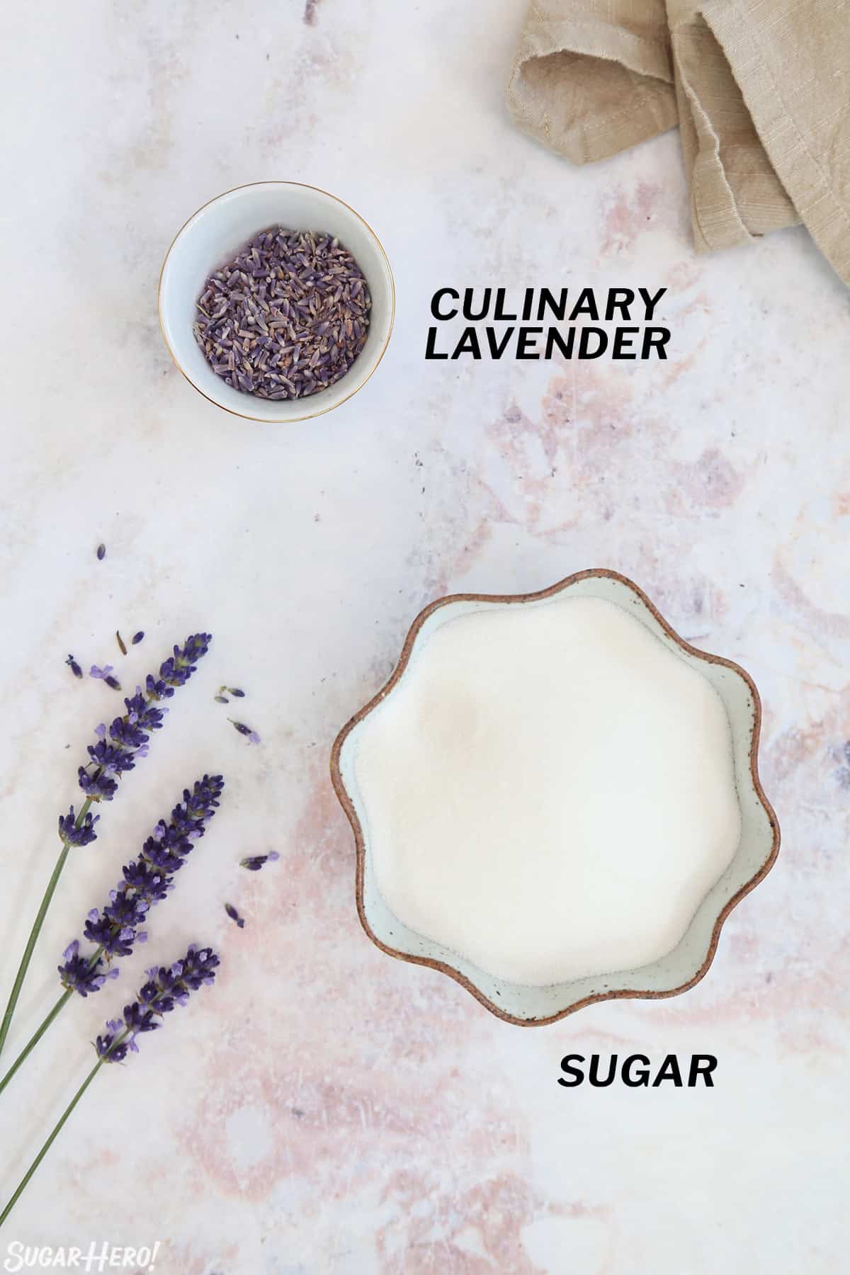 Overhead shot of the ingredients needed to make lavender sugar, on a marble surface.