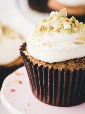 Close-up of zucchini cupcake with big dollop of cream cheese frosting on top.
