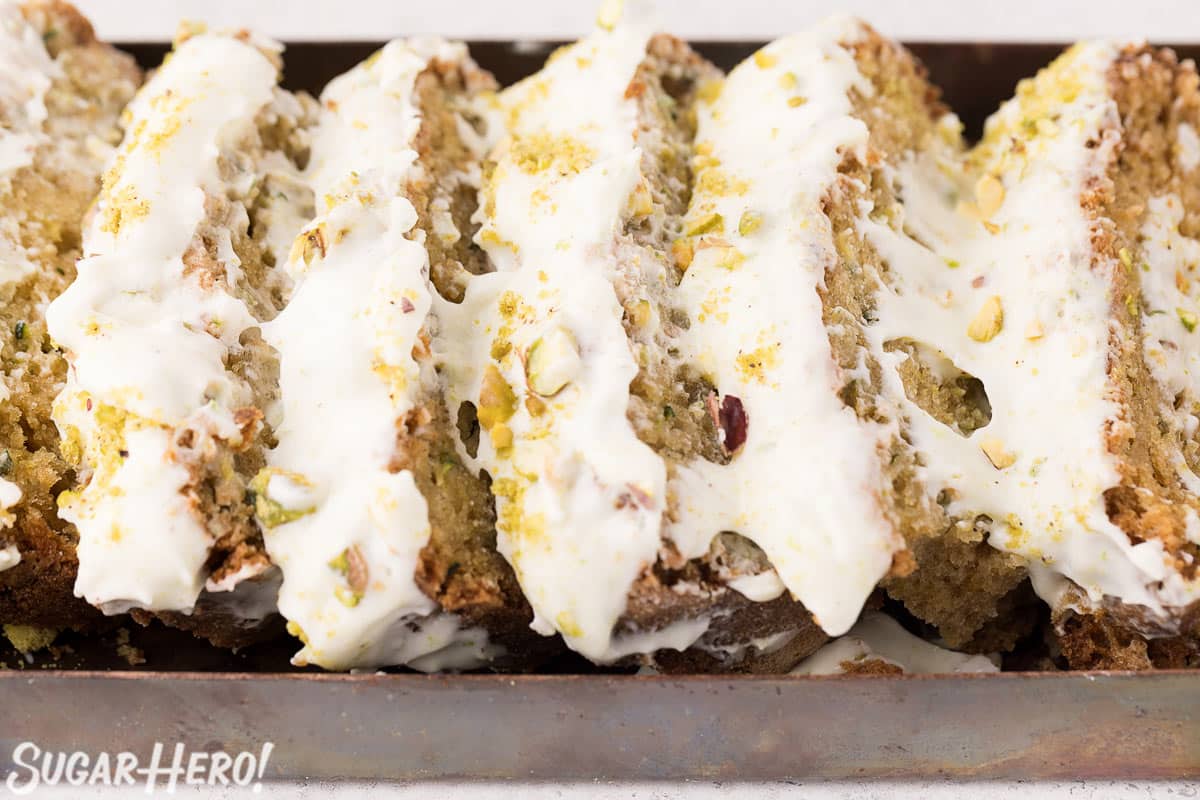 Slices of zucchini bread with gooey lime cream cheese frosting on top.