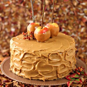 Caramel Apple Cake with Salted Caramel Buttercream on a copperplate next to fall leaves.