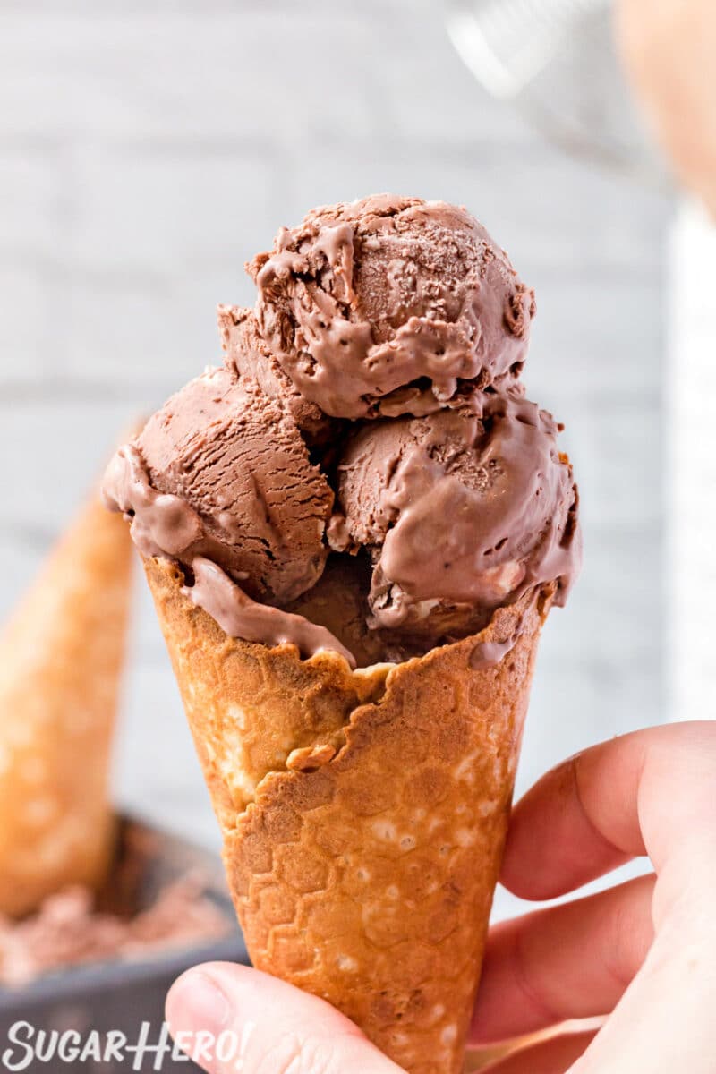 3 scoops of No-Churn Chocolate Ice Cream in a waffle cone held by a hand.