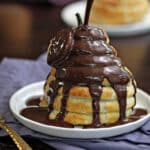 Puff Pastry-Wrapped Pear drizzled with chocolate espresso sauce on a white plate.