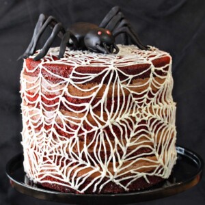 Spiderweb Naked Red Velvet Cake on a black cake stand.