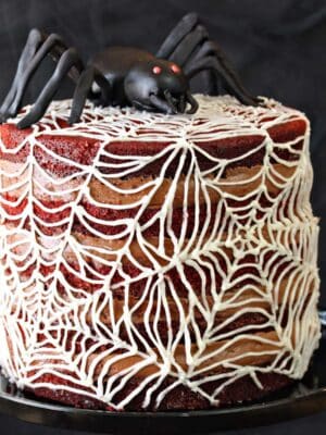 Spiderweb Naked Red Velvet Cake on a black cake stand.