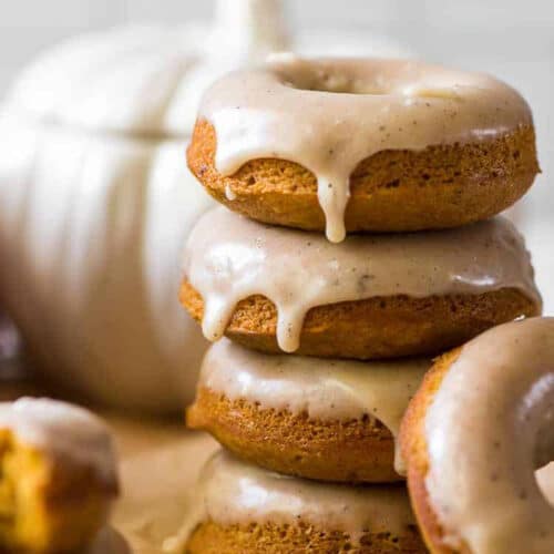 Stack of frosted pumpkin doughnuts.