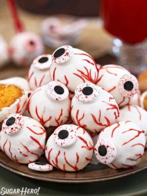Plate of Donut Hole Eyeballs with red glass in background.