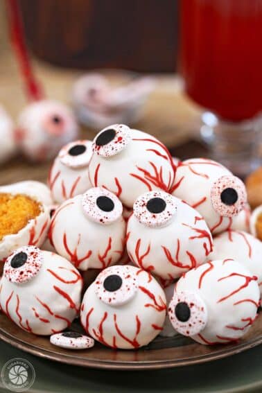 Plate of Donut Hole Eyeballs with red glass in background.