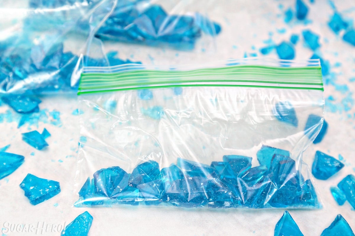 Shards of blue rock candy on white surface.