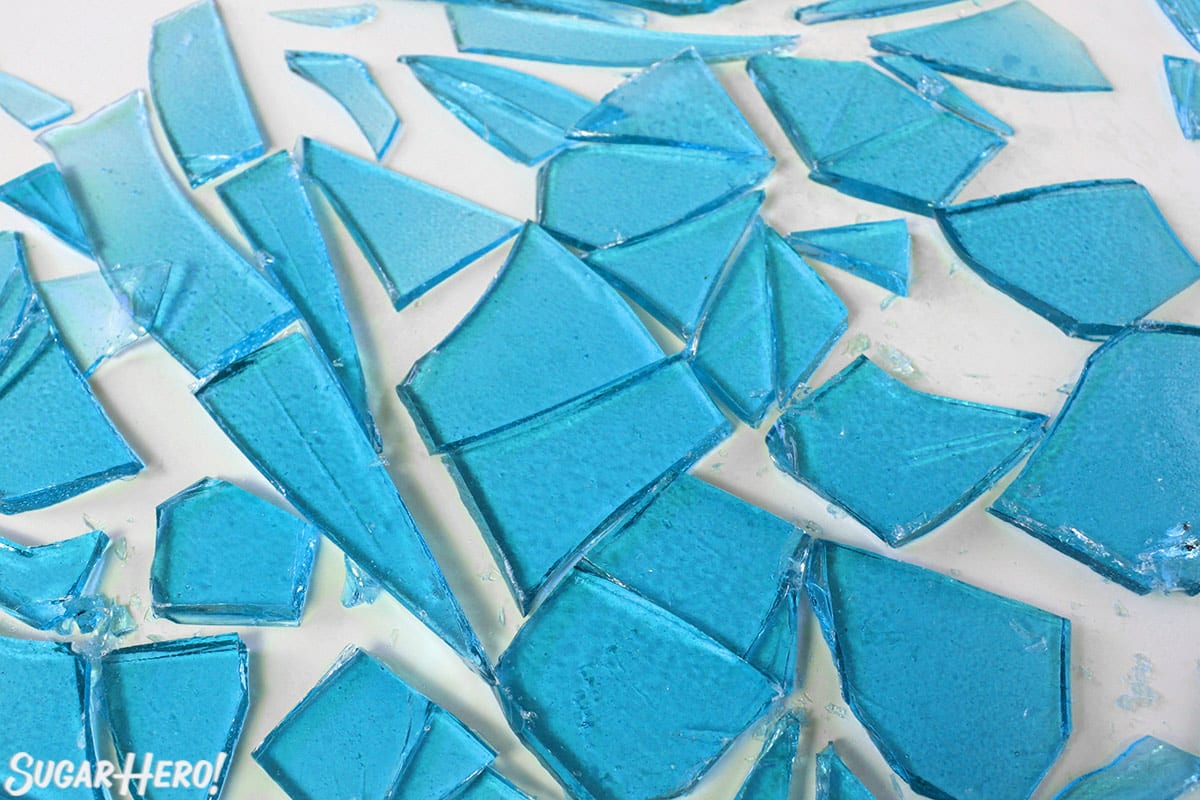 Shards of blue rock candy on white surface.