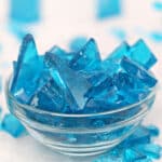 Crushed blue rock candy on wooden cutting board.
