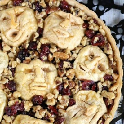 Close up of Shrunken Heads Apple Tart showing cranberries, walnuts and apple faces.