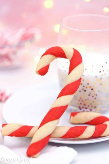 Candy Cane Cookie leaning up against a glass of milk.