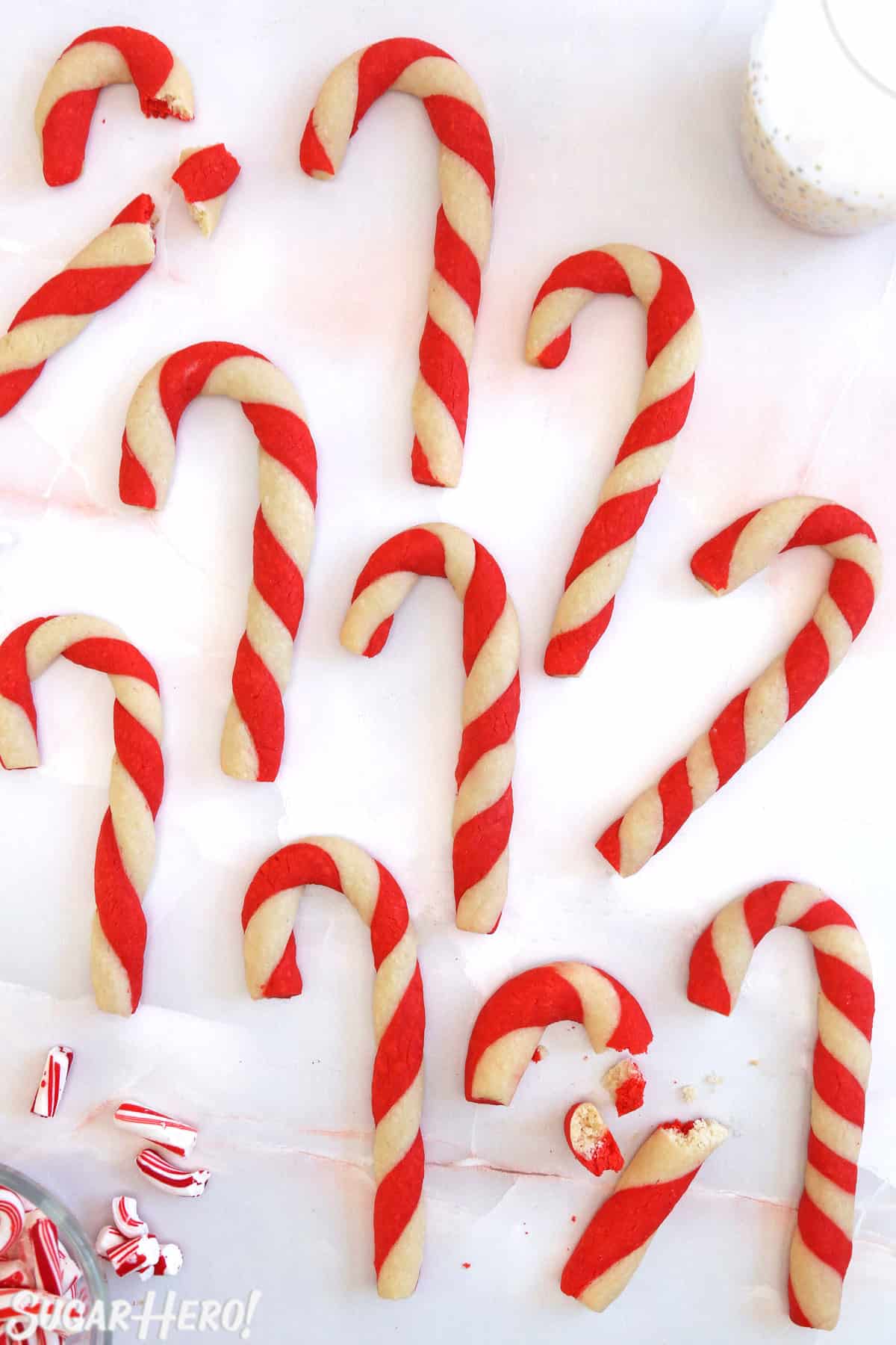 Overhead shot of Candy Cane Cookies scattered on a pink marble background.