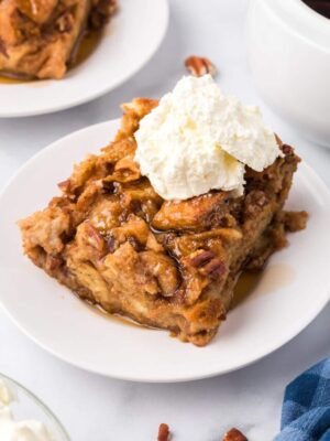 Slice of Pumpkin Bread Pudding with a scoop of whipped cream on top.