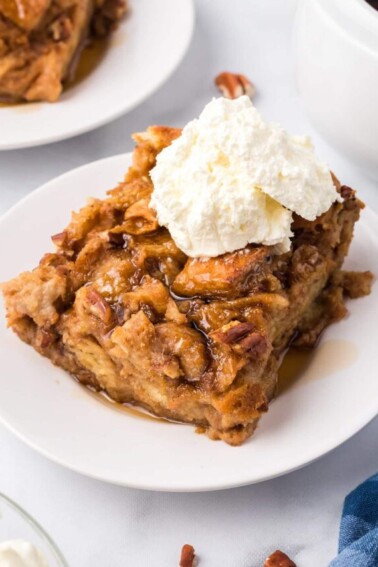 Slice of Pumpkin Bread Pudding with a scoop of whipped cream on top.