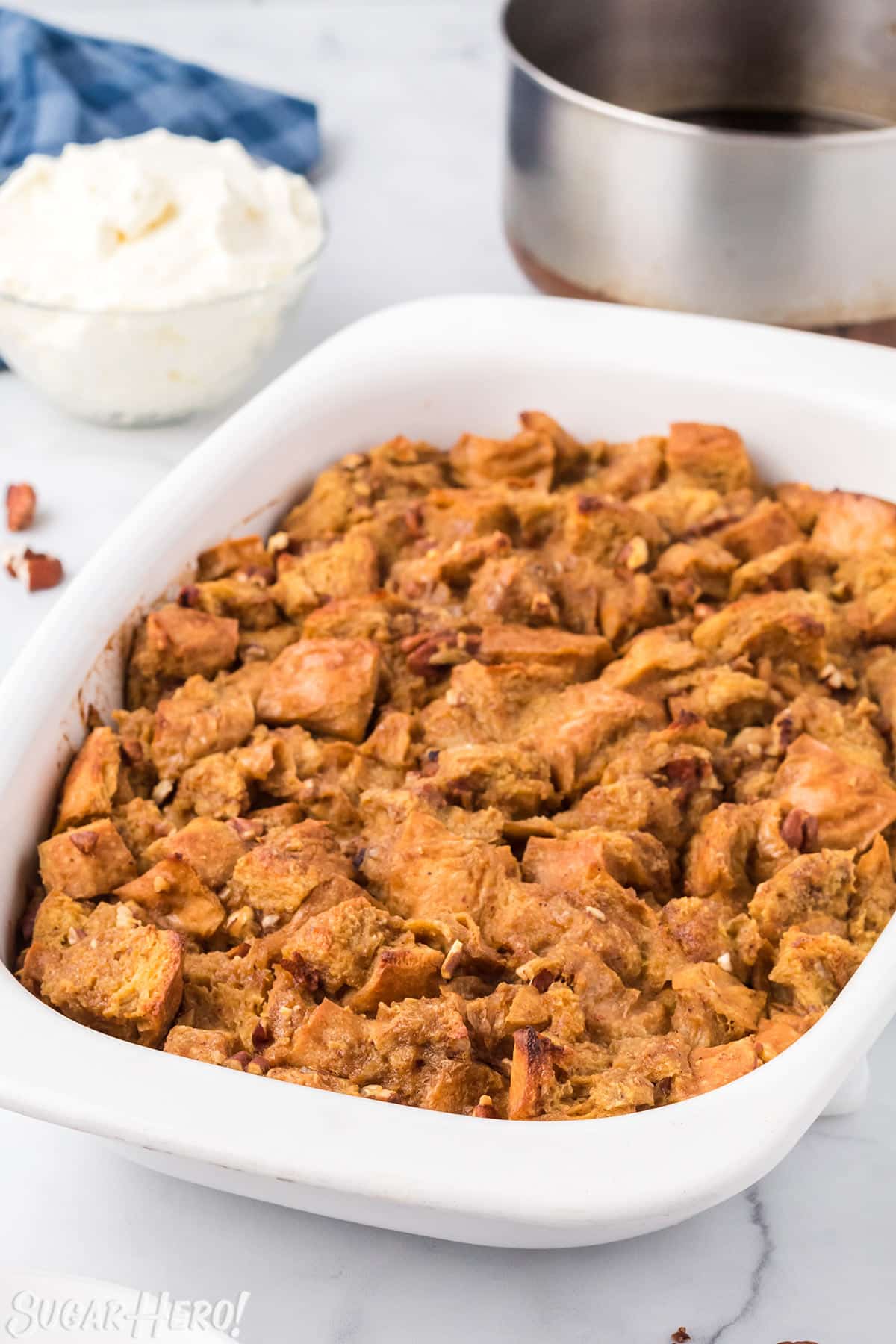 Pumpkin Bread Pudding baked in a large casserole dish, on a white marble surface.