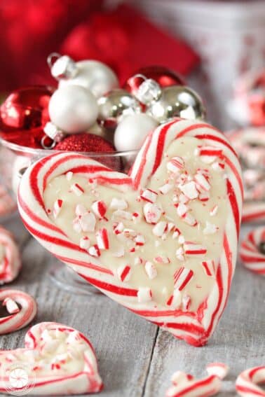Close-up of a Candy Cane Heart with white chocolate on the inside, surrounded by mini hearts around it.