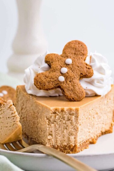 Slice of Gingerbread Cheesecake on a white plate with a bite removed on a fork.