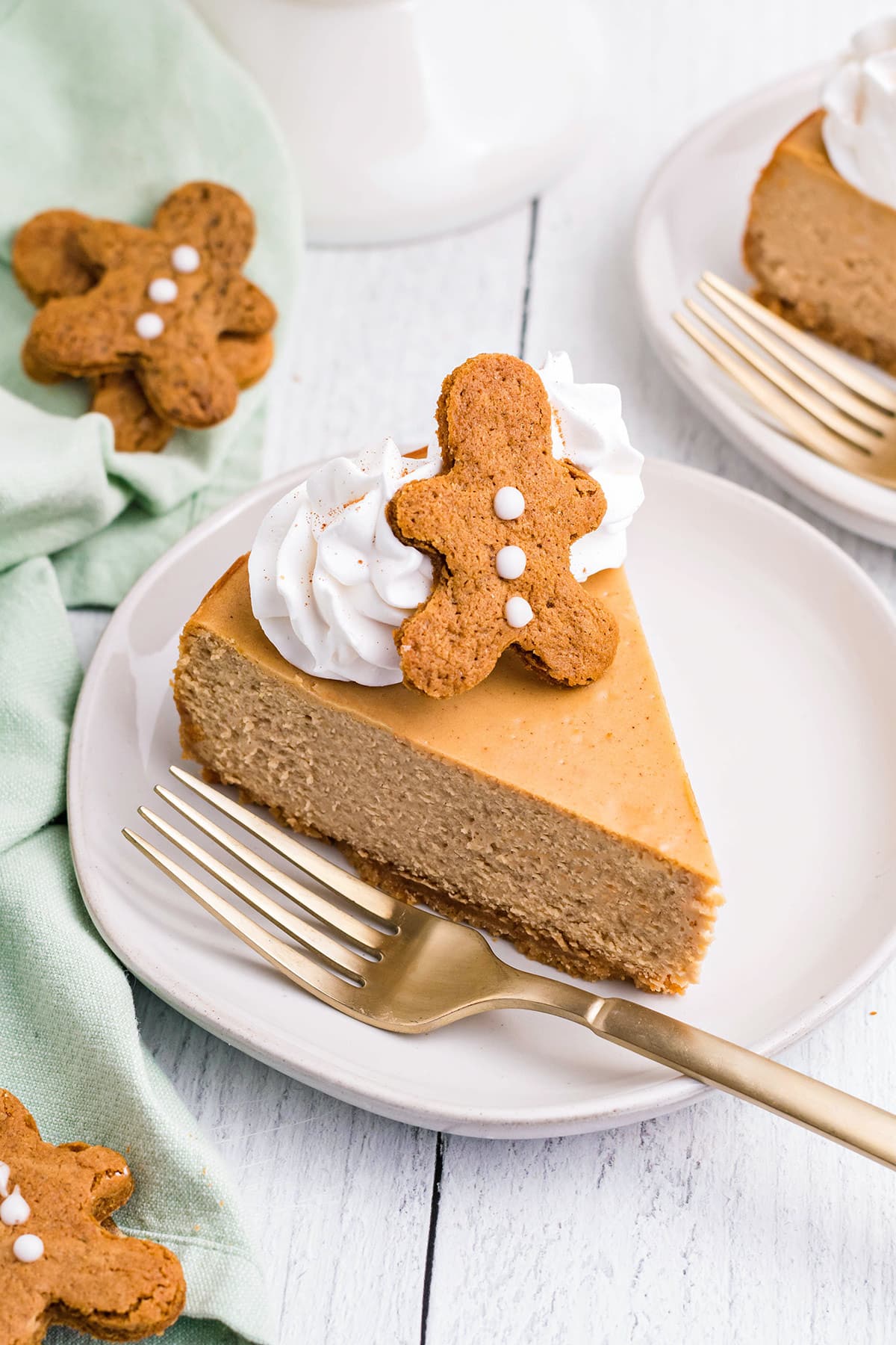 Slice of Gingerbread Cheesecake on a white plate next to a fork.