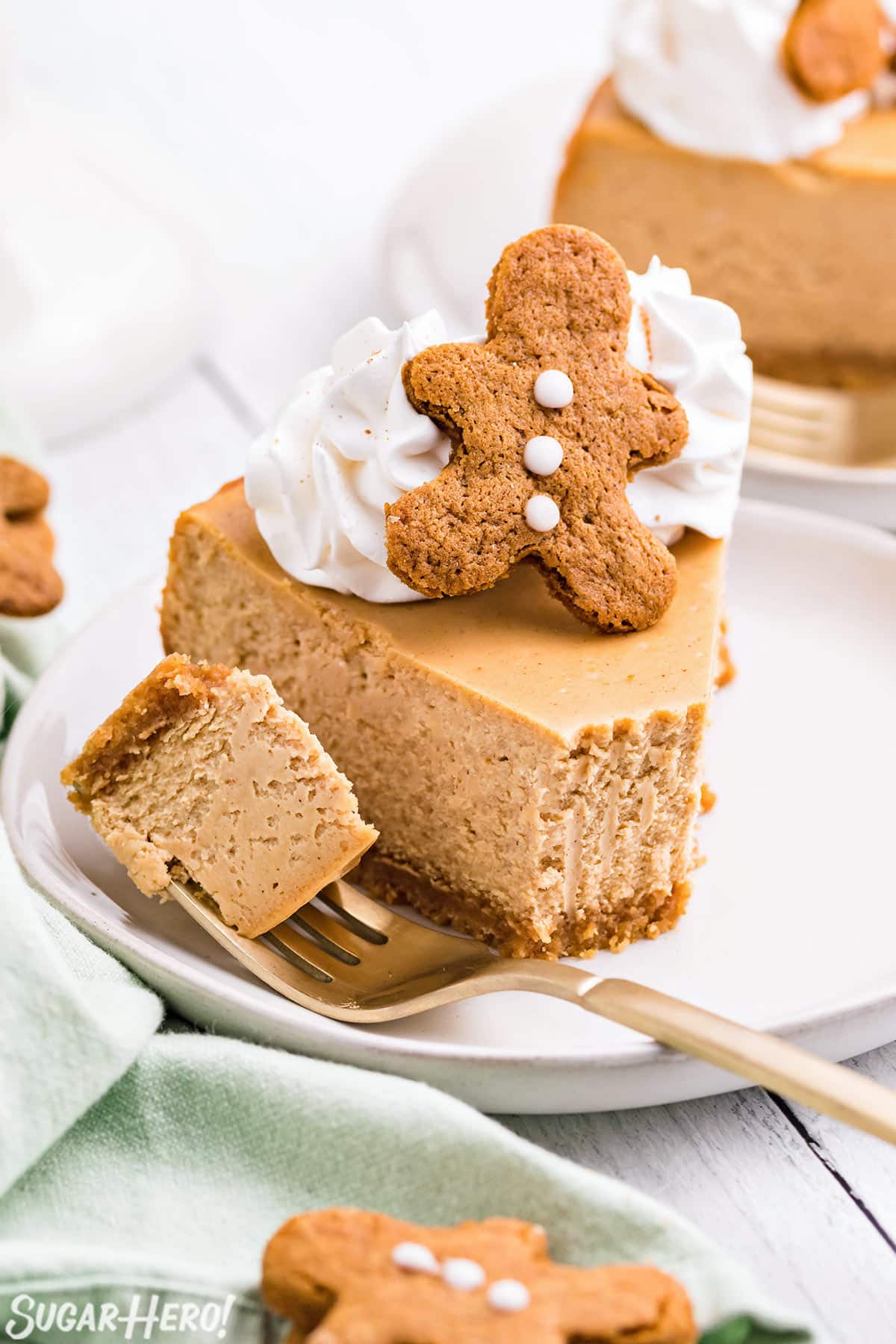 Slice of Gingerbread Cheesecake on a white plate with a bite removed on a fork.