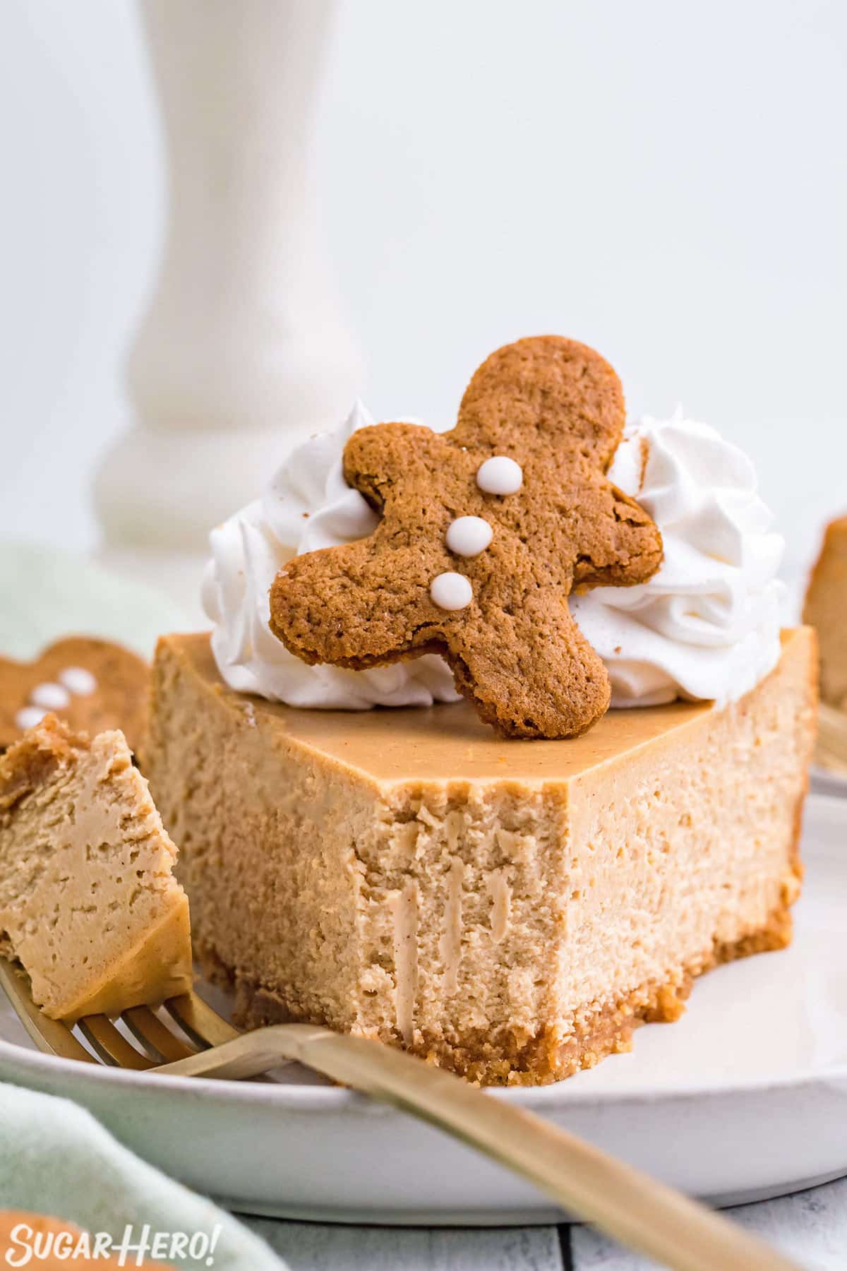 Slice of Gingerbread Cheesecake on a white plate with a bite removed on a fork.