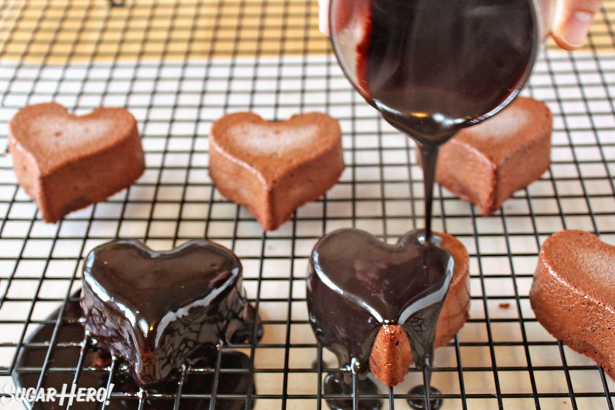 Frozen Salted Caramel Chocolate Mousse in the shape of hearts being covered with chocolate.