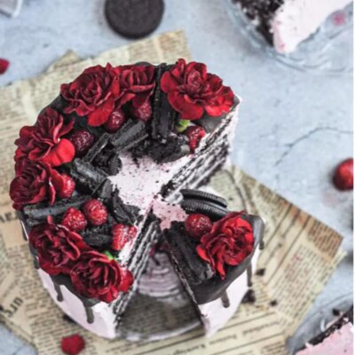 Top view of a Chocolate Berry Cake with a few slices removed on top of newspaper.