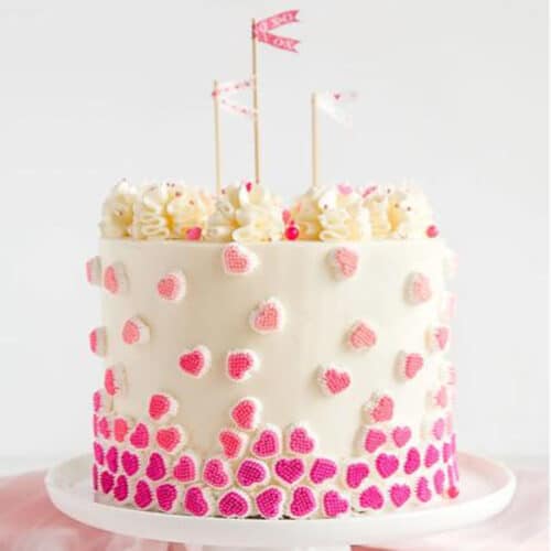 Pink Velvet cake on a white cake platter.