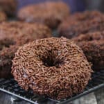 Close up of Chocolate Blackout Doughnuts on a wire drying rack.