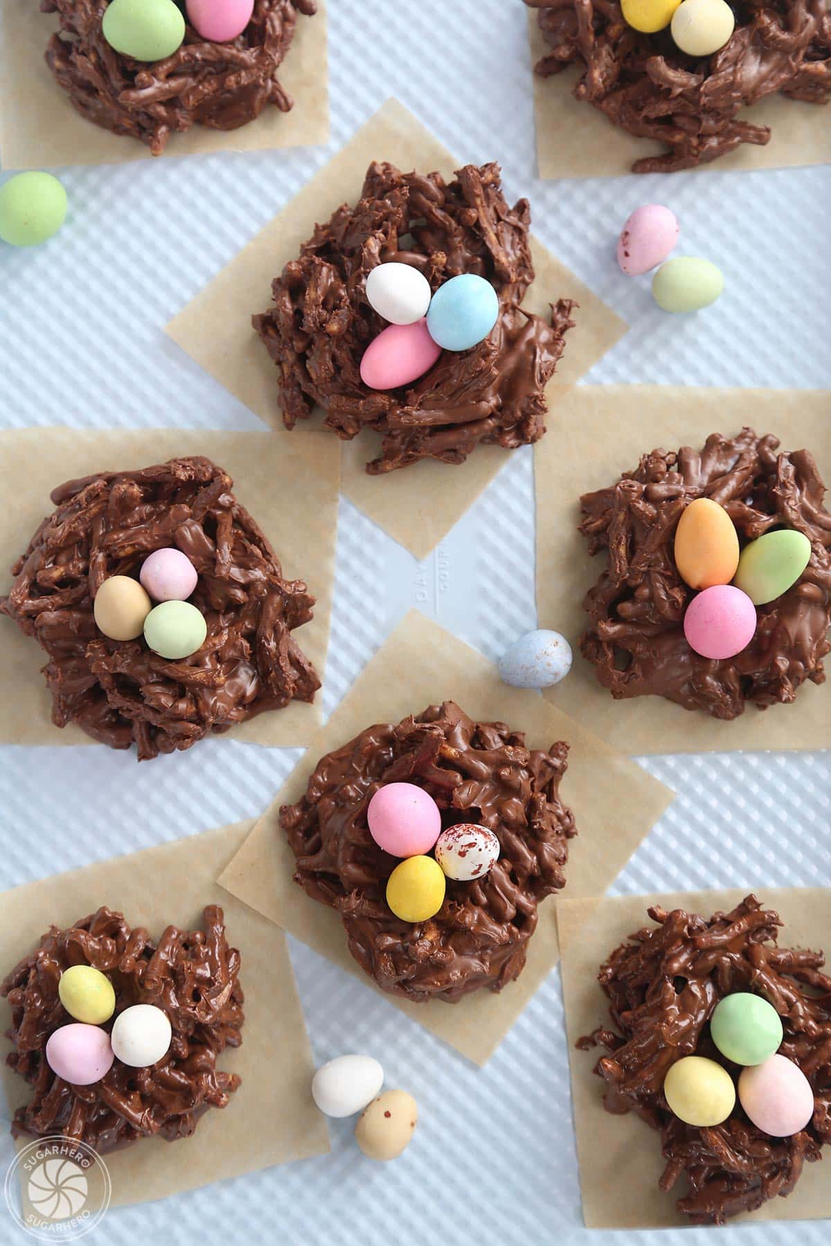 Top view of Chocolate Easter Nests on brown parchment on a blue baking sheet.